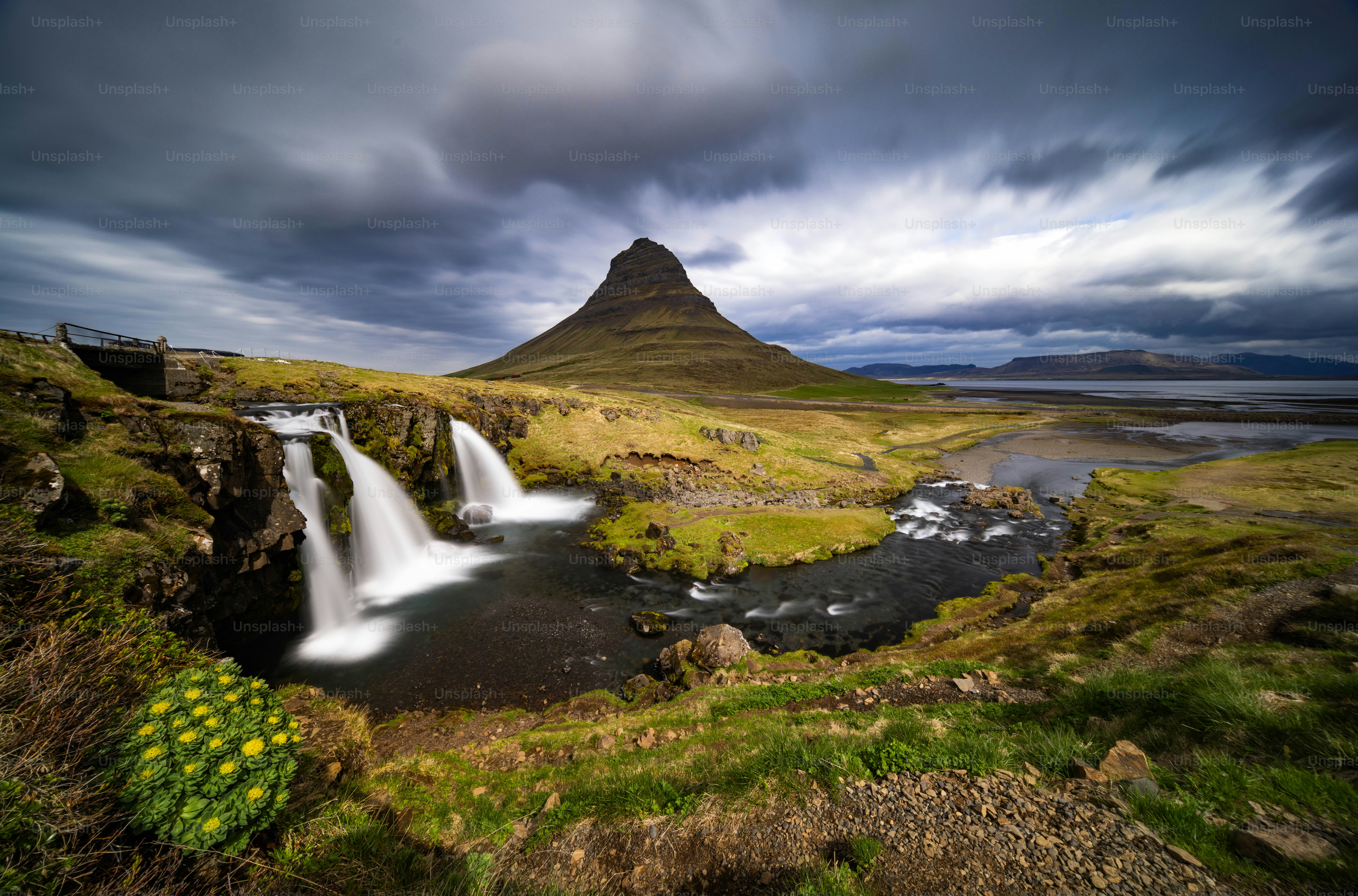 a waterfall with a mountain in the background