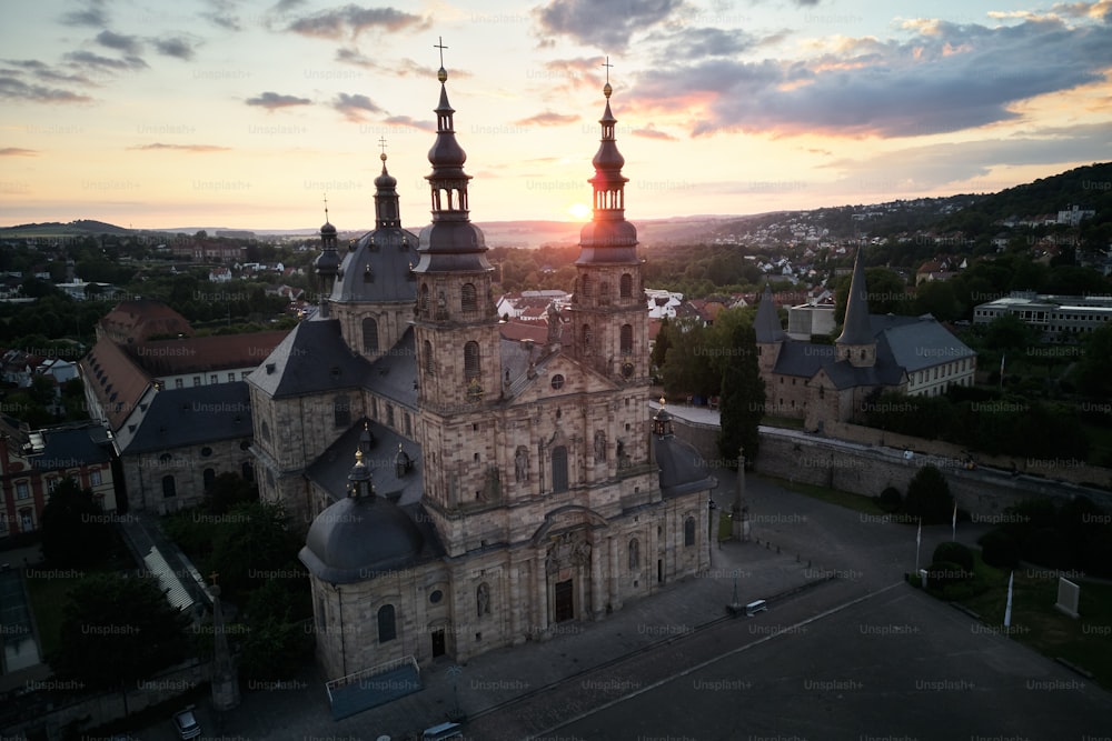 uma vista aérea de uma igreja com um pôr do sol ao fundo