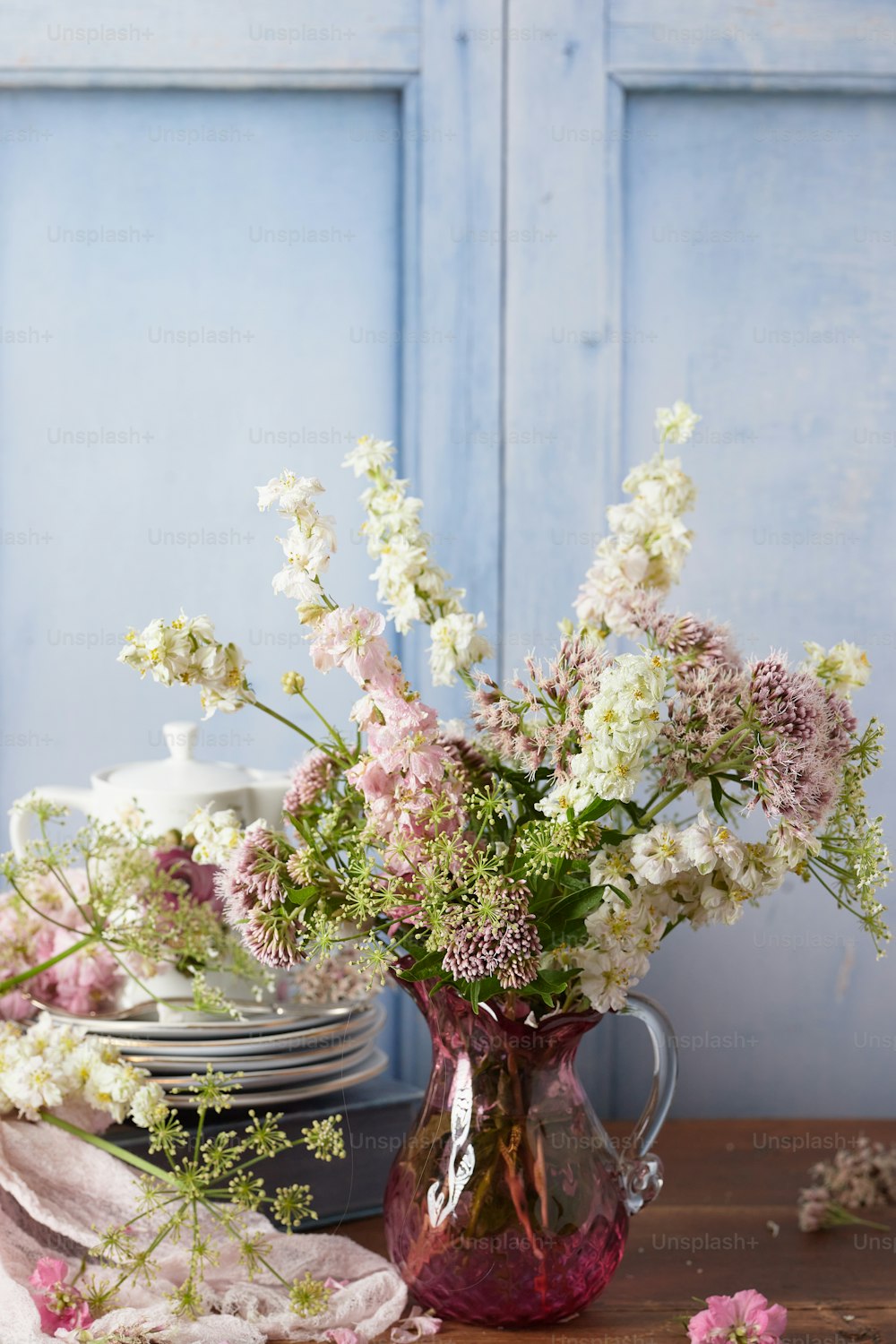 a vase filled with lots of white and pink flowers