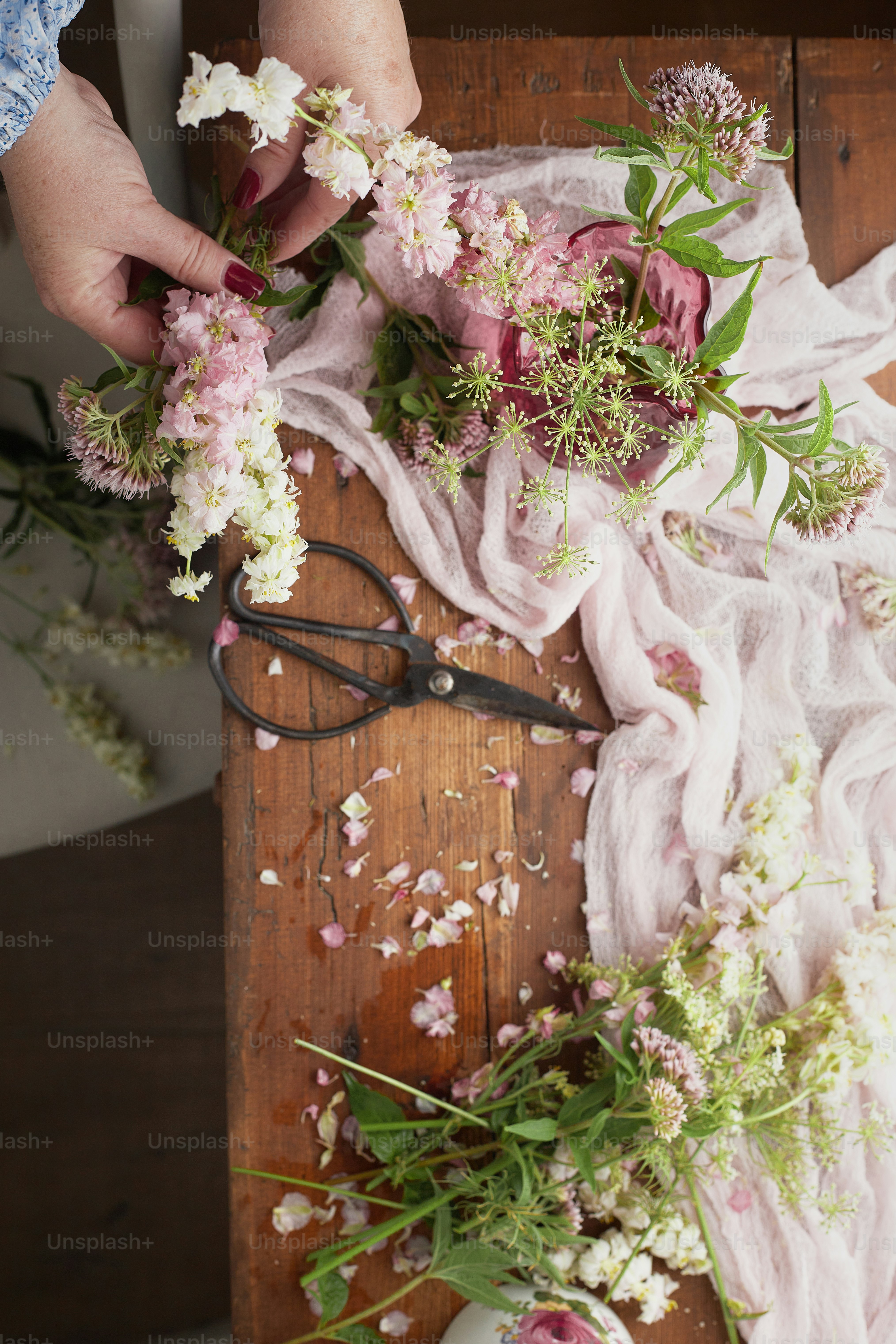 a person cutting flowers with a pair of scissors
