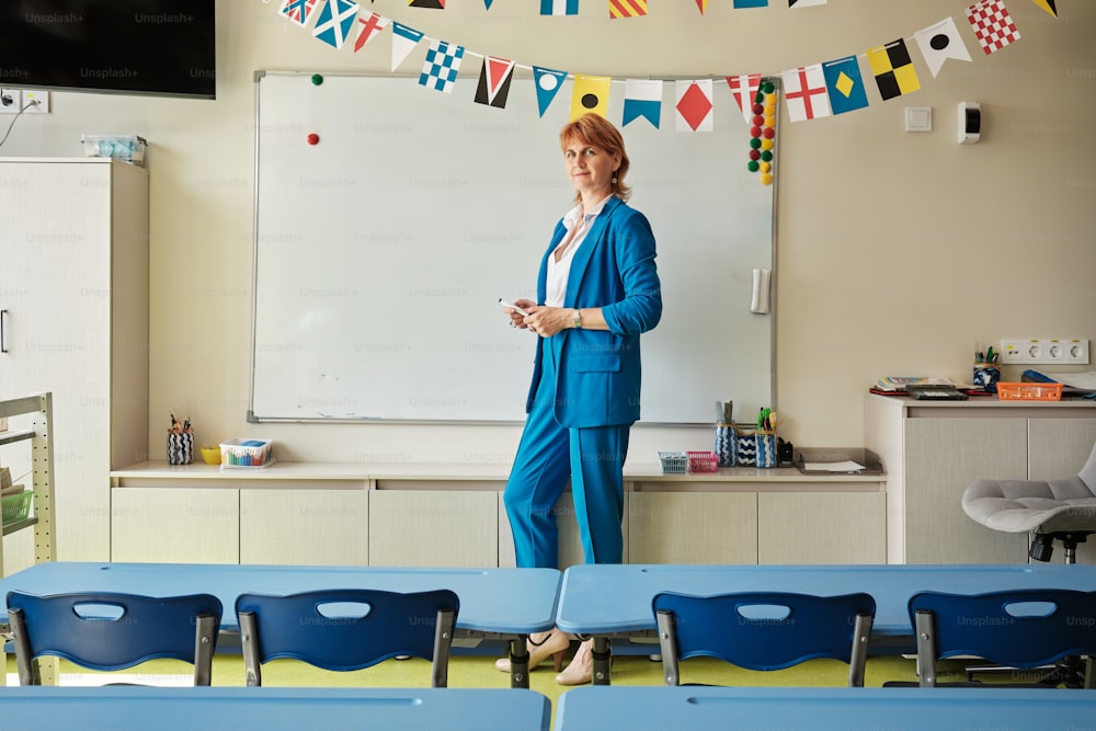 Una donna in piedi davanti a una lavagna in un'aula
