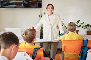 a woman standing in front of a group of children