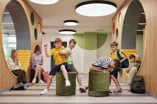 a group of children sitting on bean bags in a room
