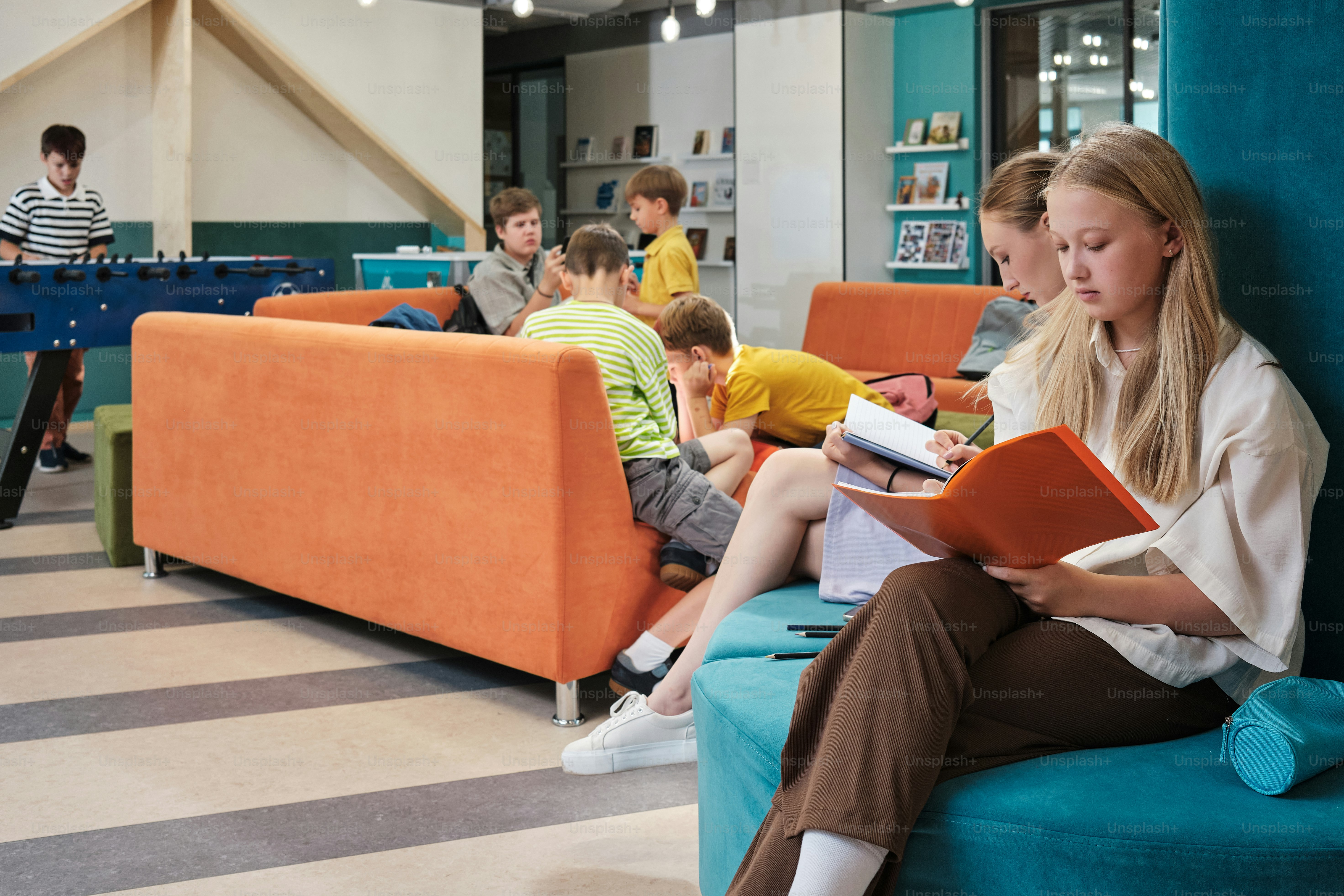 a woman sitting on a couch reading a book