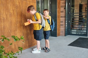 two young boys are standing outside of a building