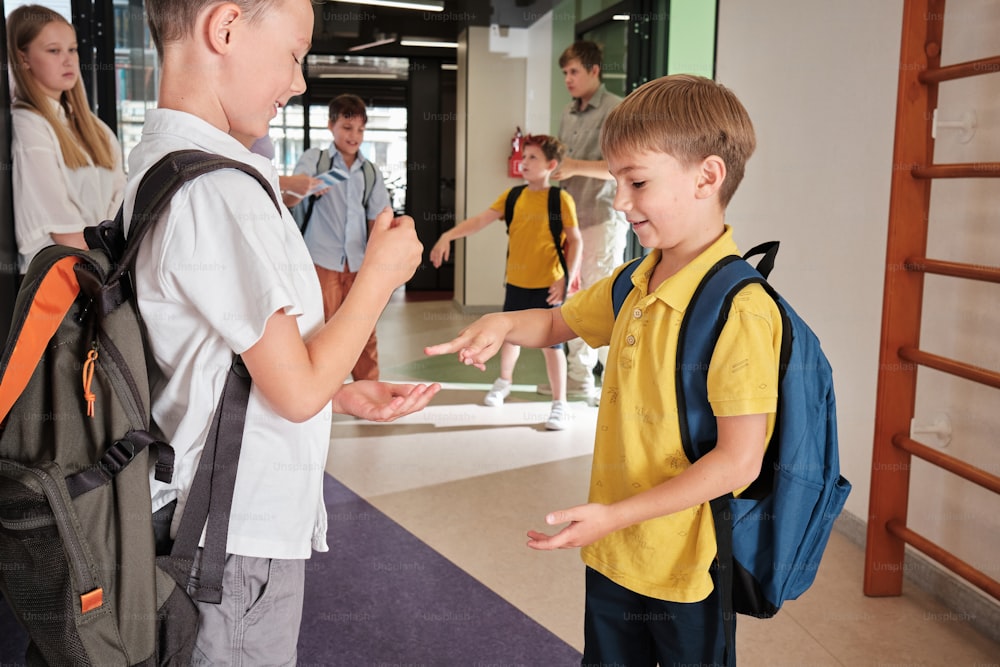 two young boys are talking to each other