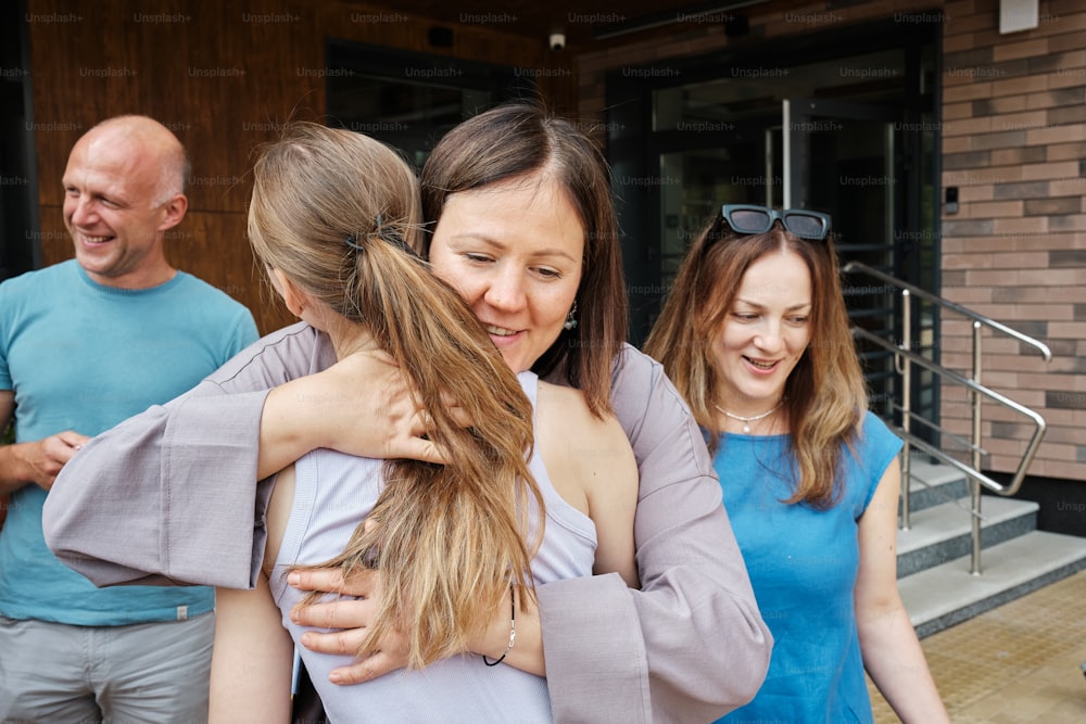 a group of people hugging each other outside of a building