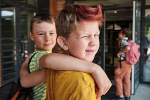 Dos niños pequeños abrazándose fuera de un edificio
