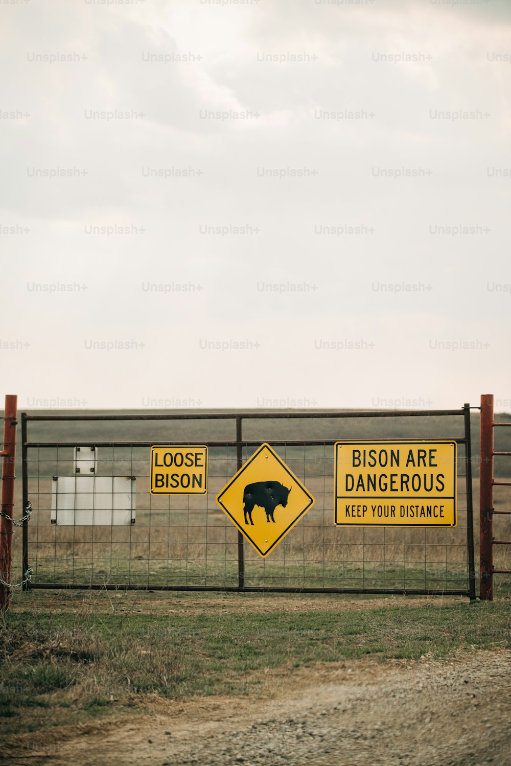 Una cerca con un letrero que dice que los bisontes son peligrosos