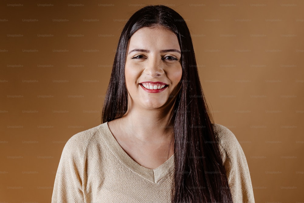 Una donna con lunghi capelli scuri che sorride alla macchina fotografica