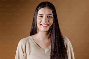 Une femme aux longs cheveux noirs souriant à la caméra