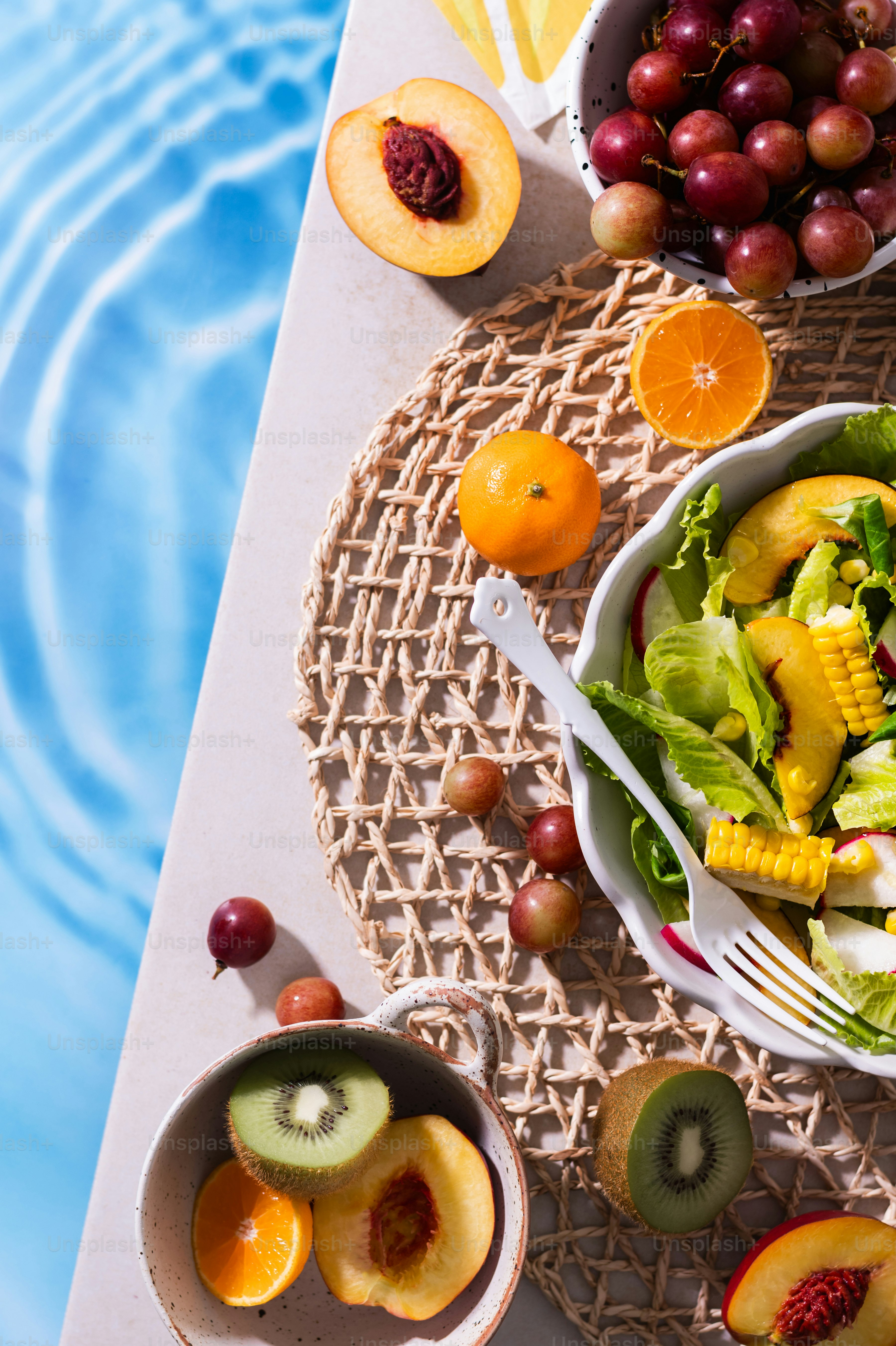 a bowl of fruit is next to a bowl of salad
