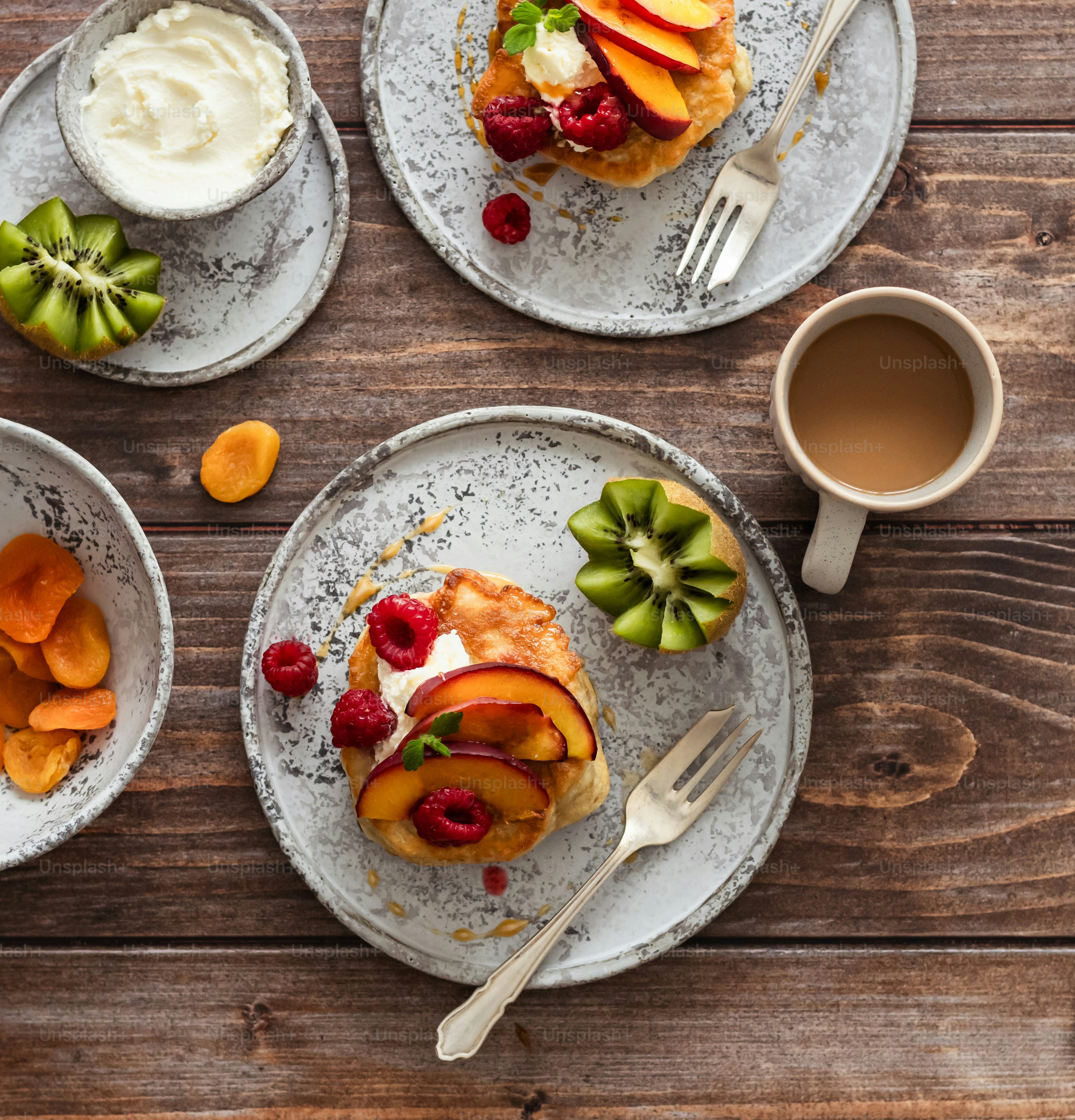 a table topped with plates of food and a cup of coffee