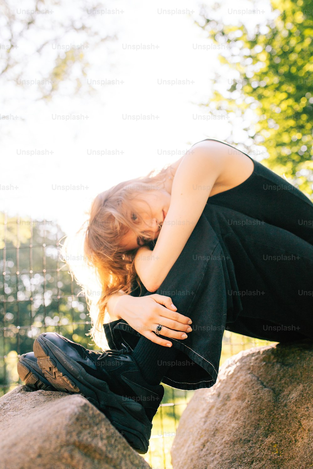 uma mulher sentada em cima de uma grande rocha