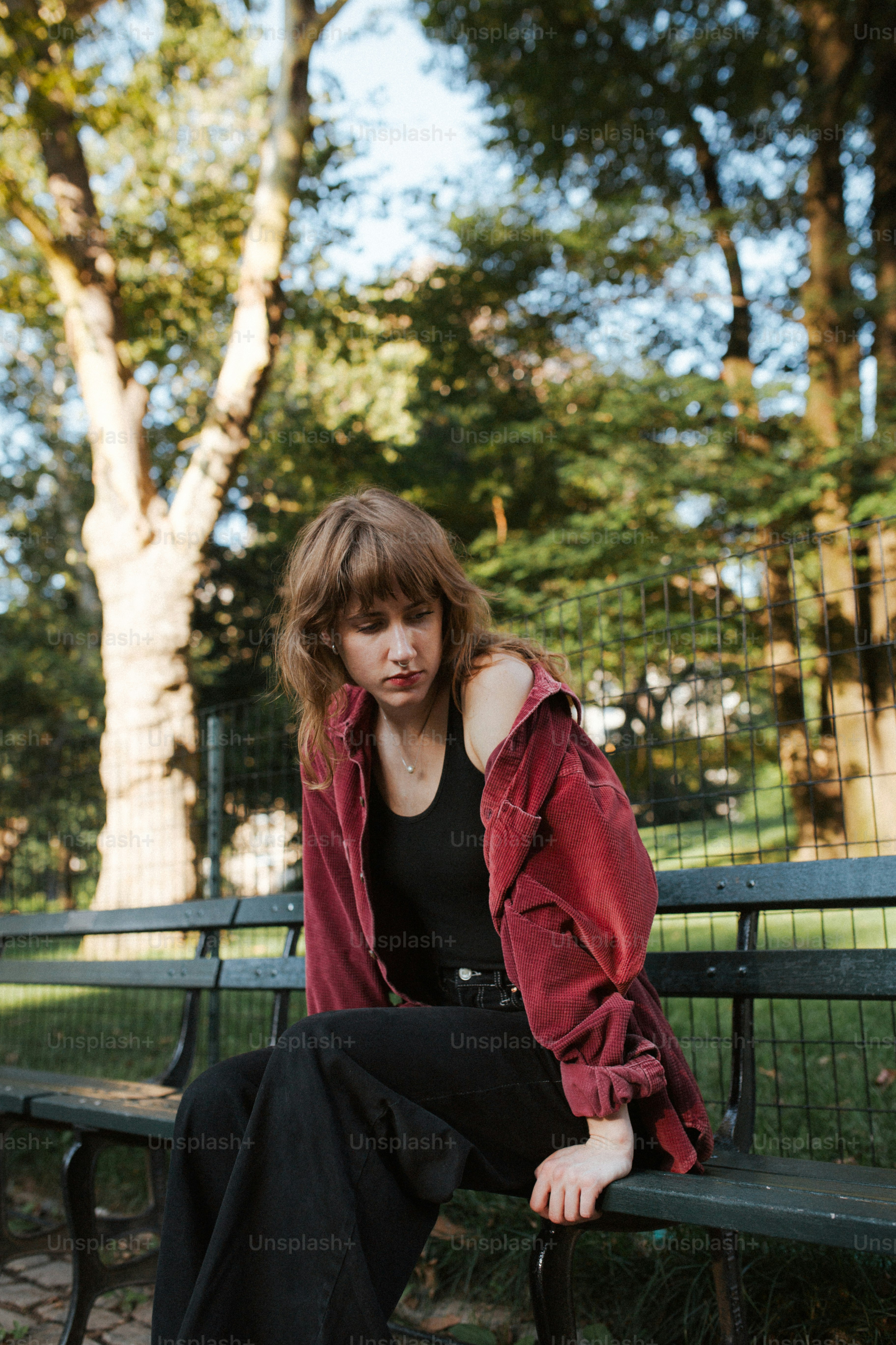 a woman sitting on a bench in a park