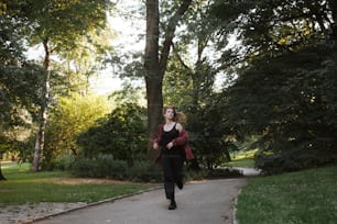 a woman walking down a path in a park