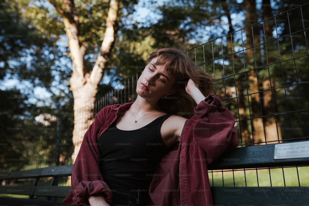 a woman sitting on a bench in a park