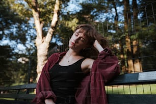 a woman sitting on a bench in a park