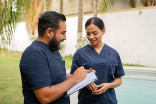 a man and a woman in scrubs standing next to a pool