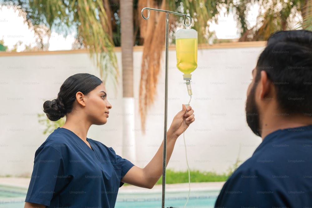 a woman in scrubs is holding a sprayer in her hand