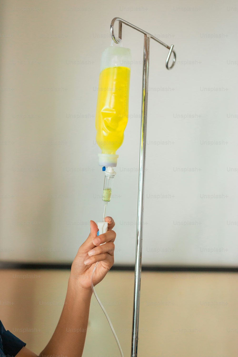 a person is holding a yellow liquid in a tube