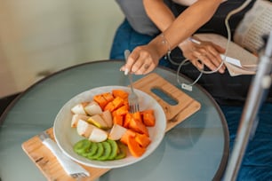 Una mujer cortando verduras en una tabla de cortar