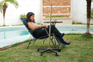 a woman sitting in a chair next to a pool