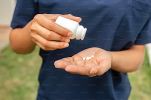 une personne tenant un flacon de pilules dans ses mains