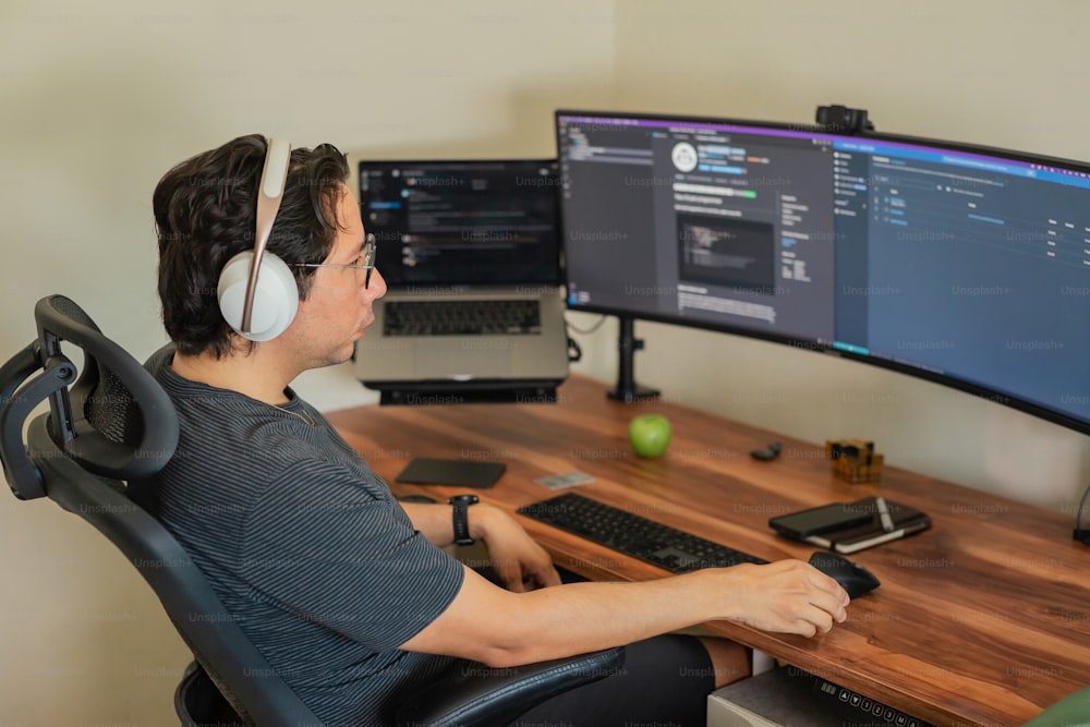 a man sitting at a desk with headphones on