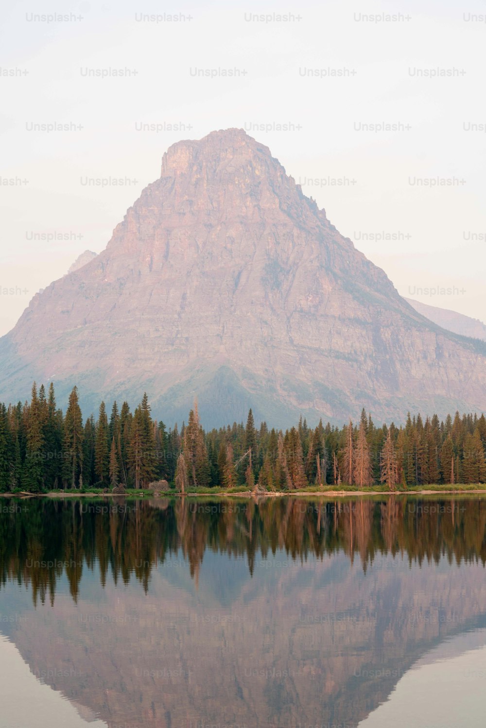 Una montagna si riflette nell'acqua ferma di un lago