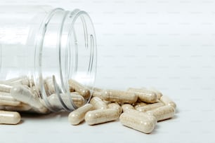 a glass jar filled with pills on top of a white table