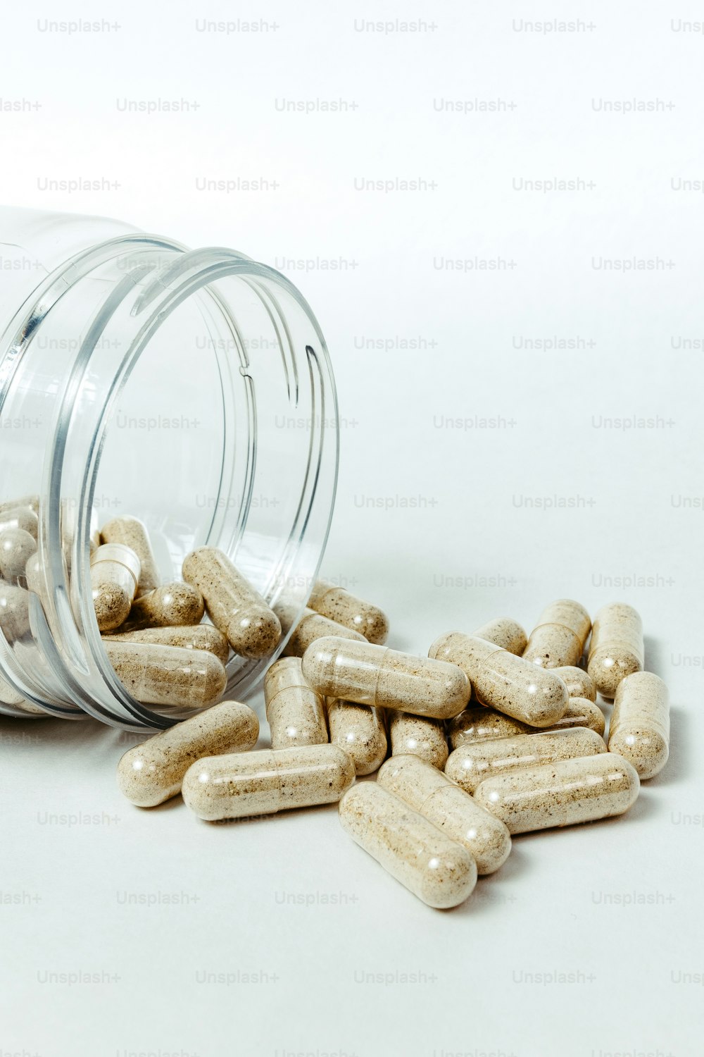 a glass jar filled with white pills on top of a table