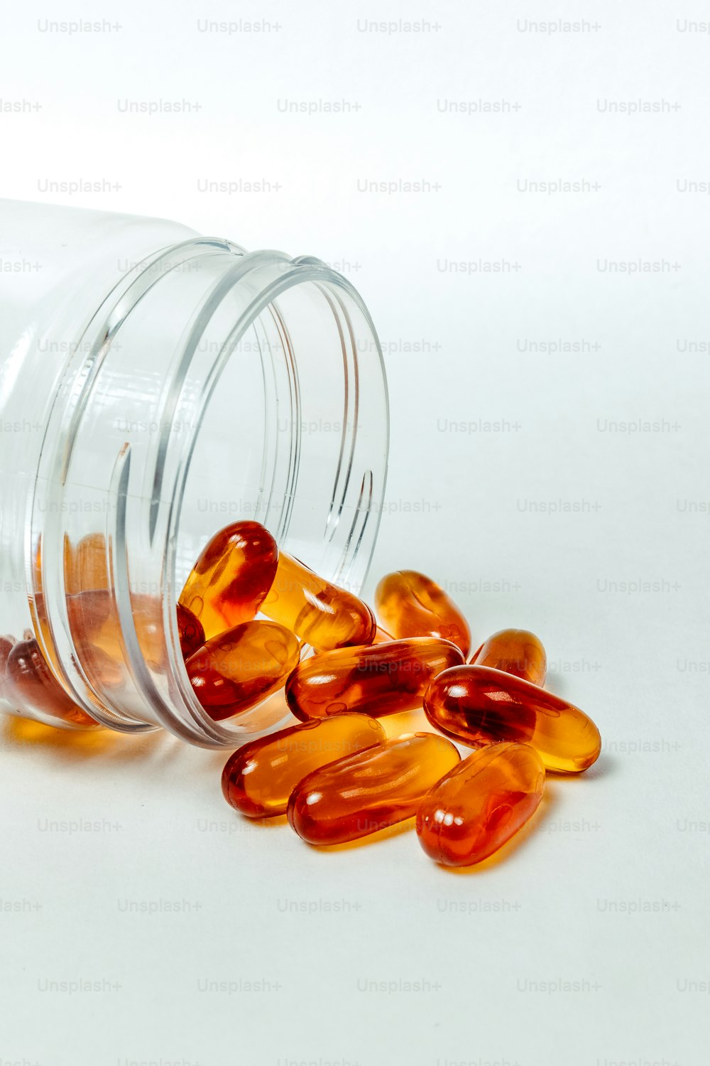 a glass jar filled with pills on top of a white table