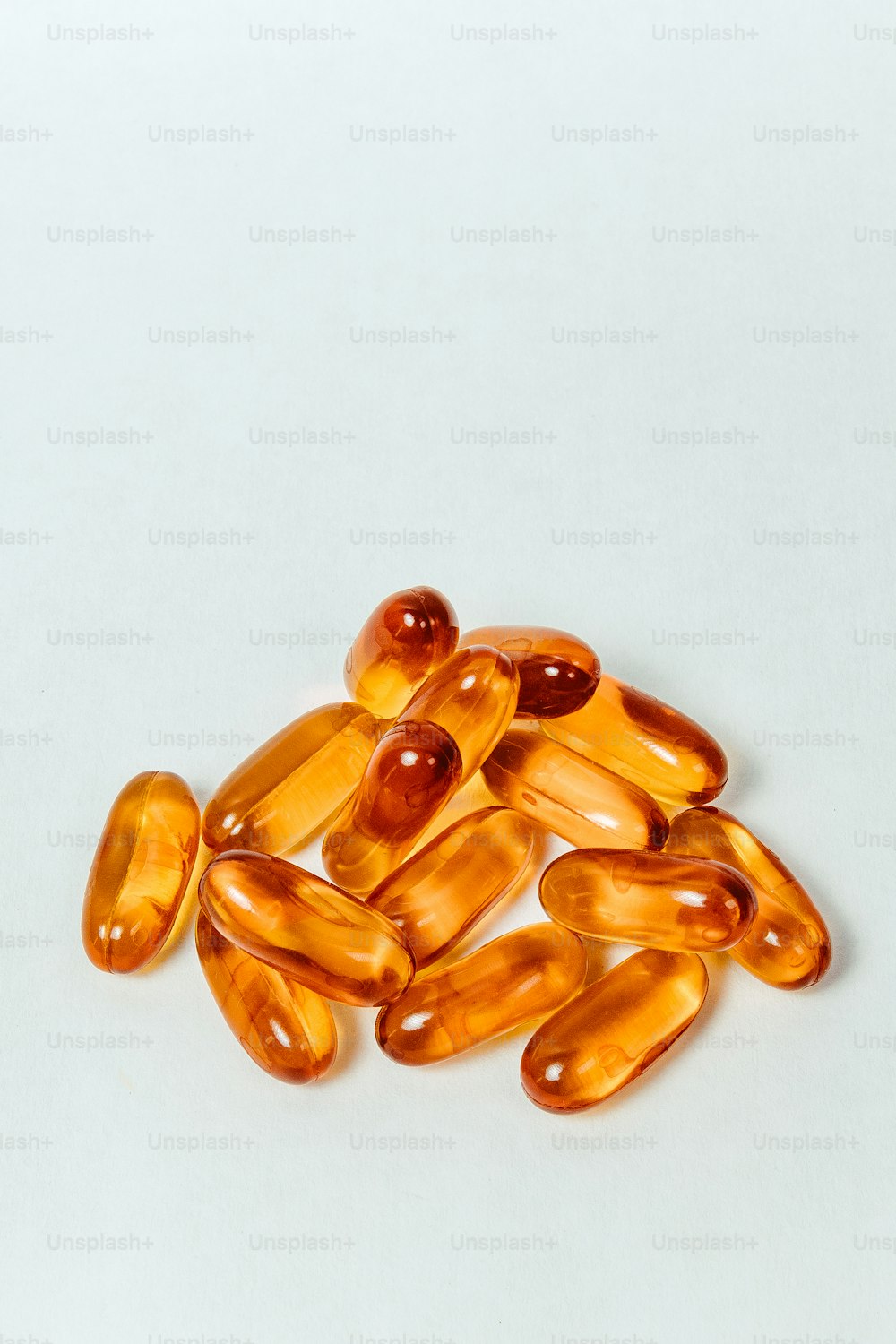 a pile of fish oil capsules on a white surface