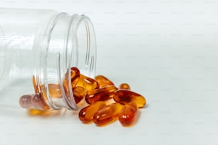a glass jar filled with pills on top of a white table