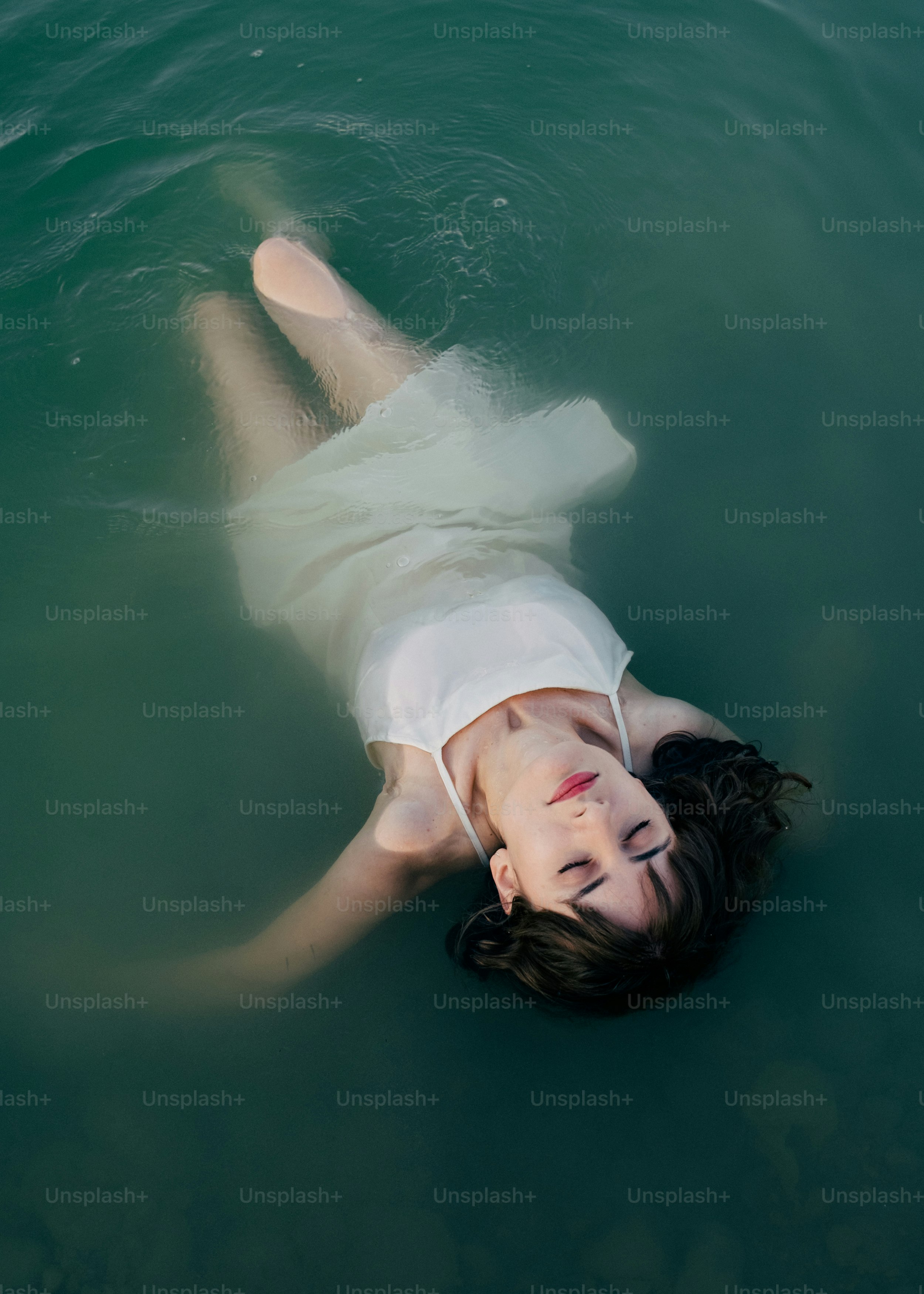 A woman in a body of water wearing a white dress photo – Expressive ...