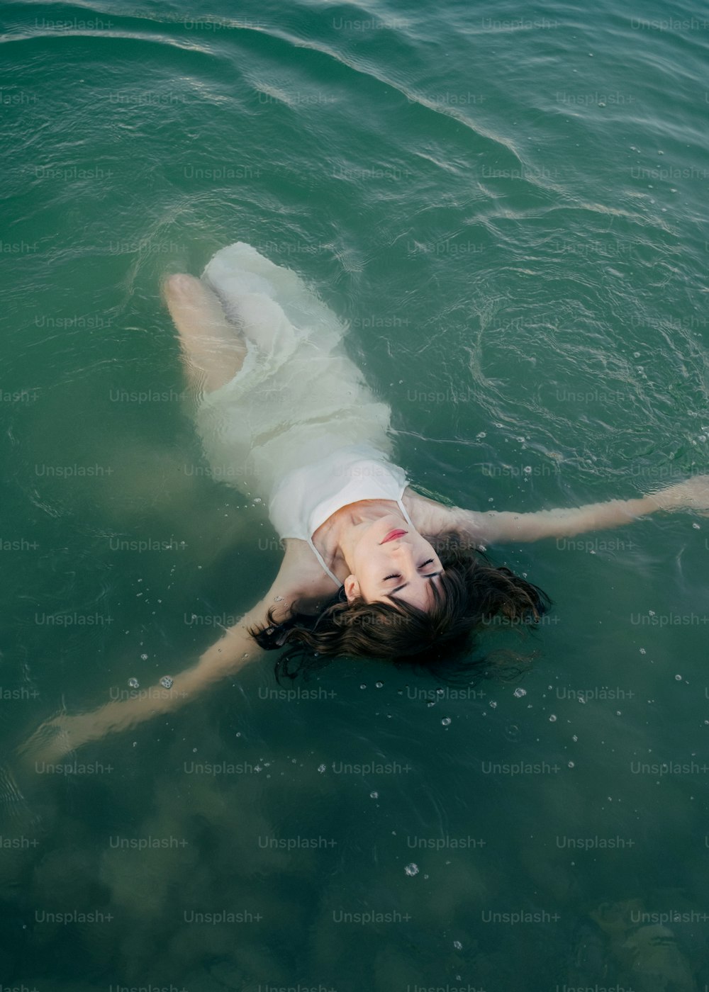 uma mulher deitada em uma prancha de surf na água
