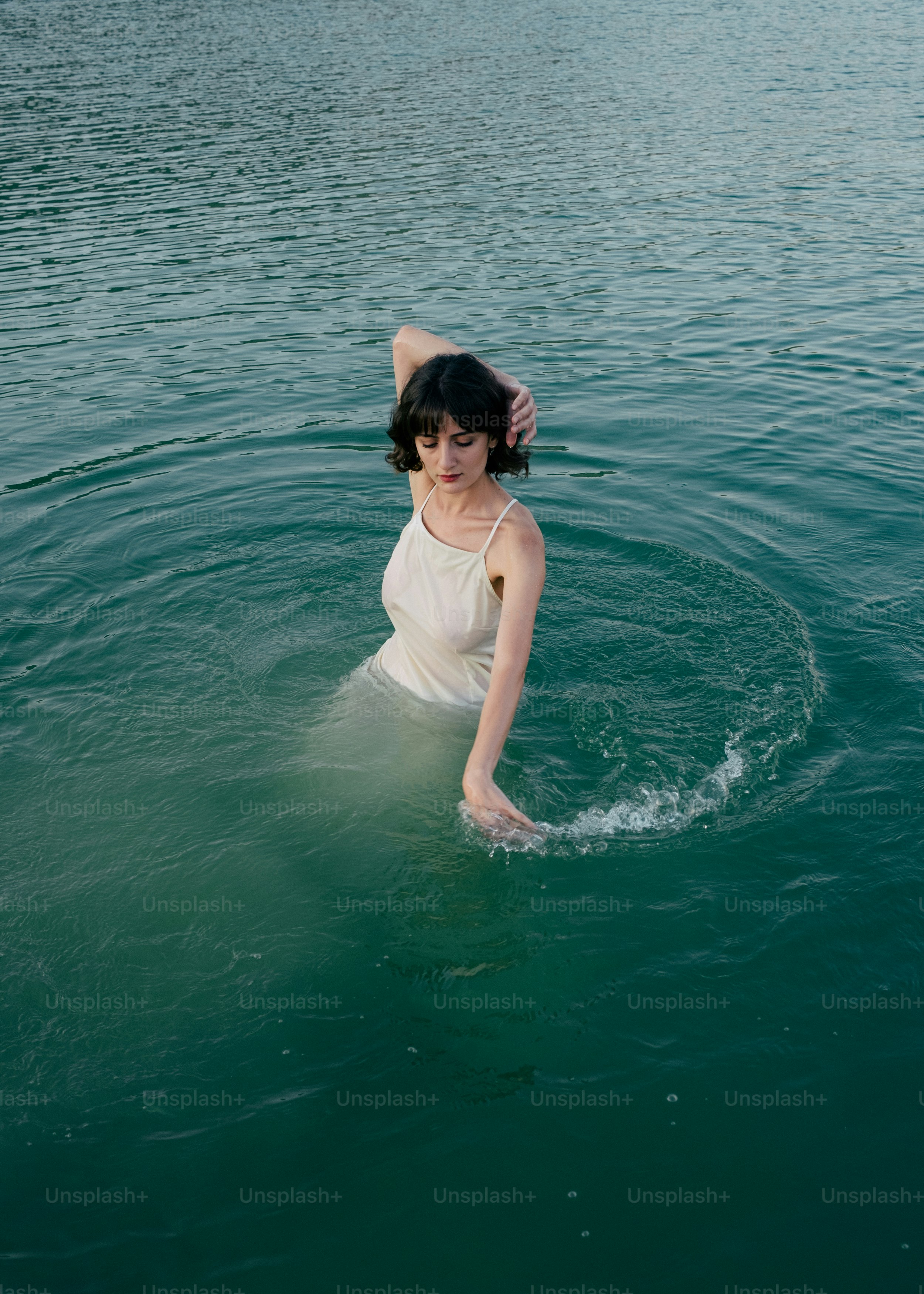 A woman in a body of water wearing a white dress photo – Expressive ...
