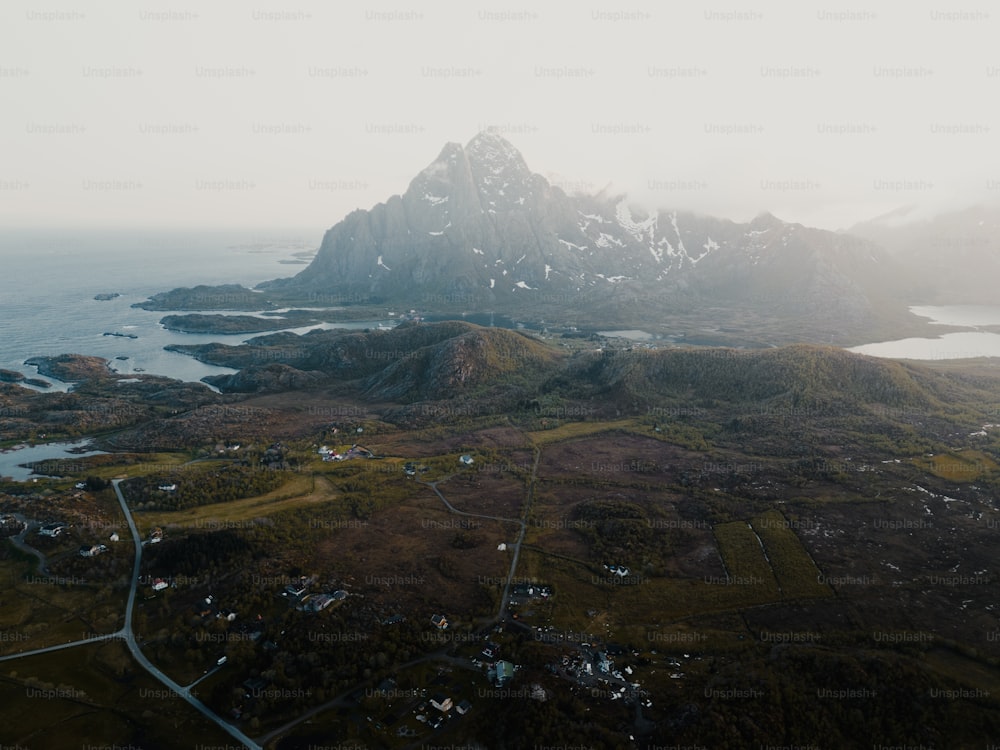 an aerial view of a mountain range with a body of water