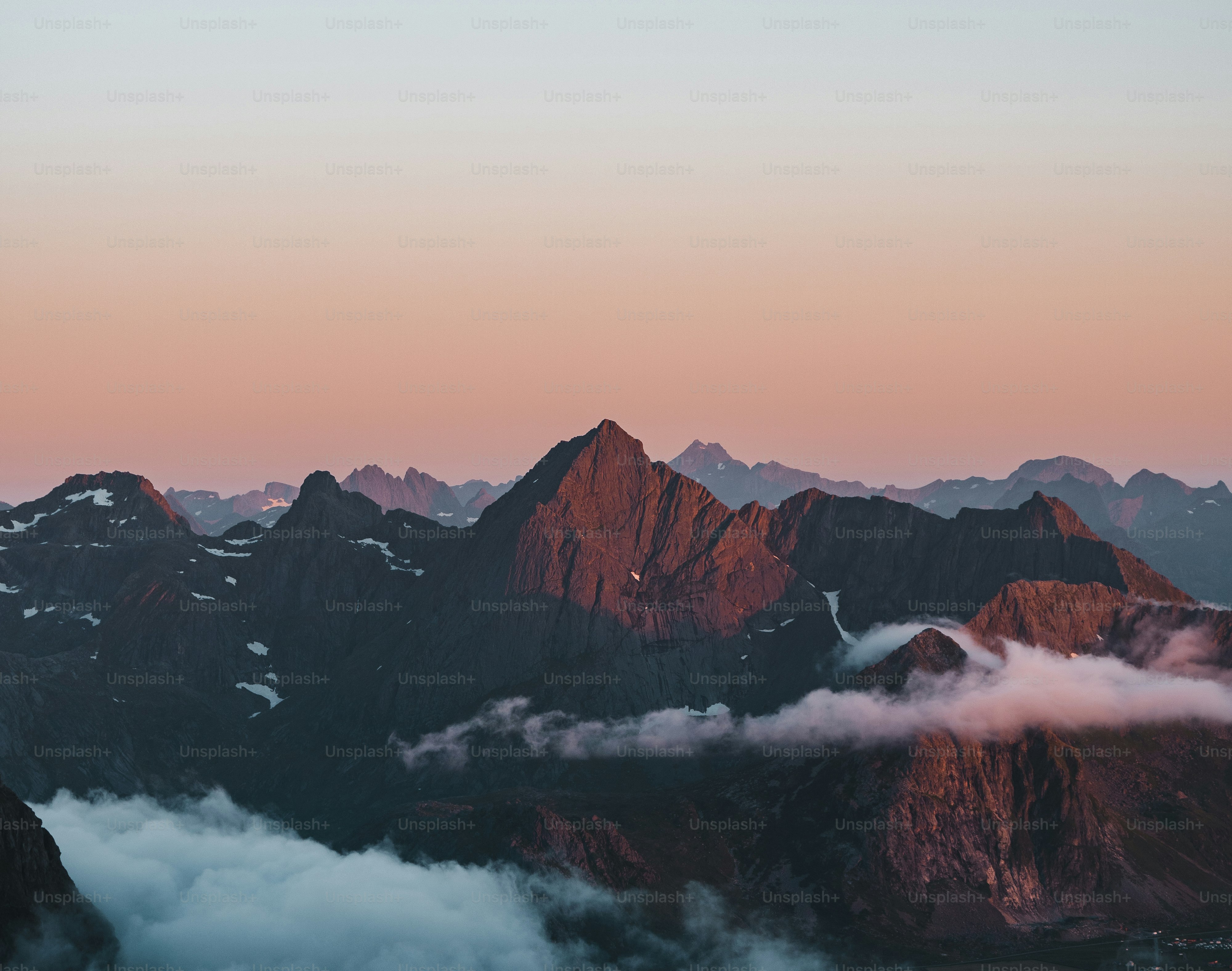 A view of a mountain range with a pink sky photo – Clouds Image on Unsplash