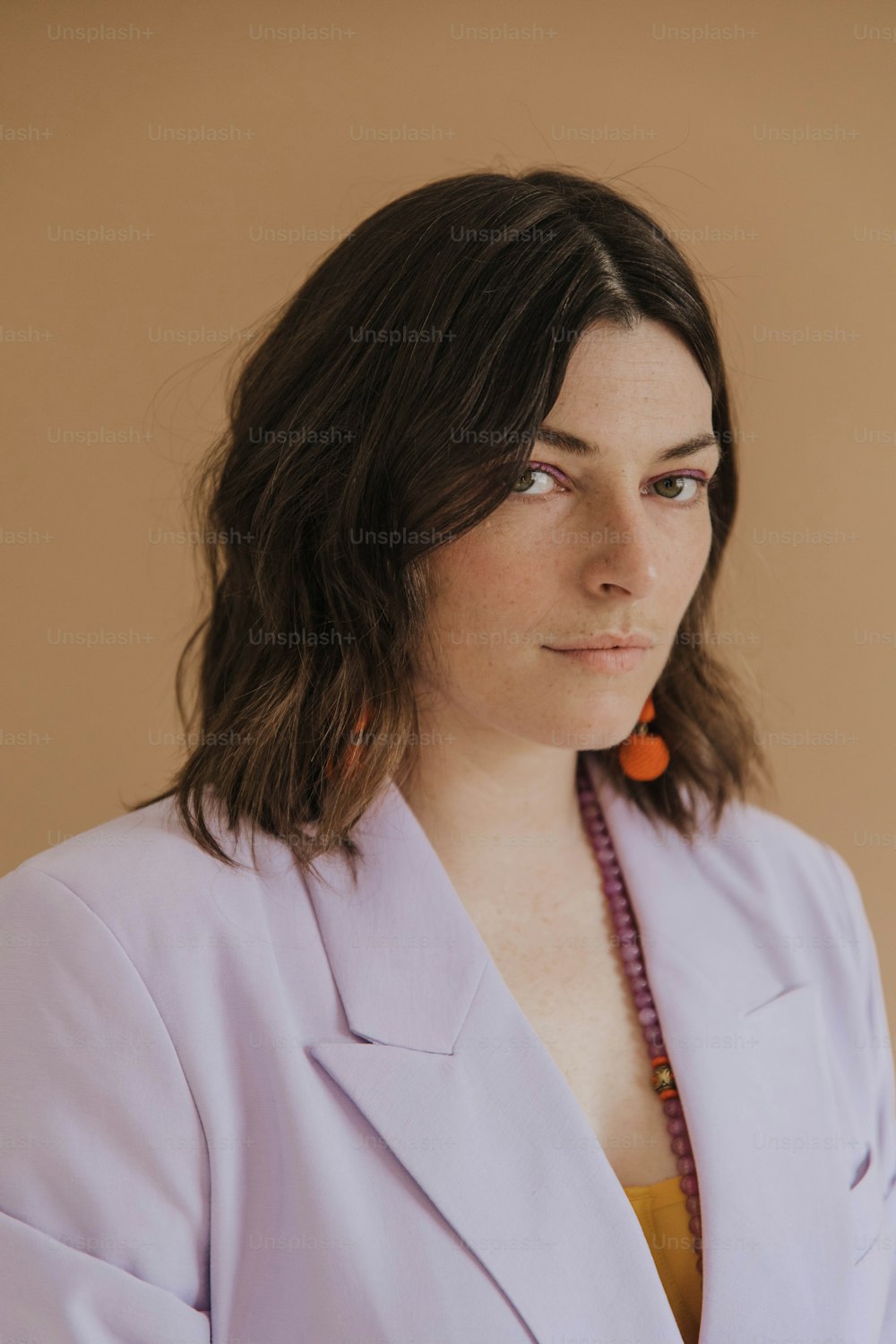 uma mulher vestindo uma jaqueta roxa e um colar de contas