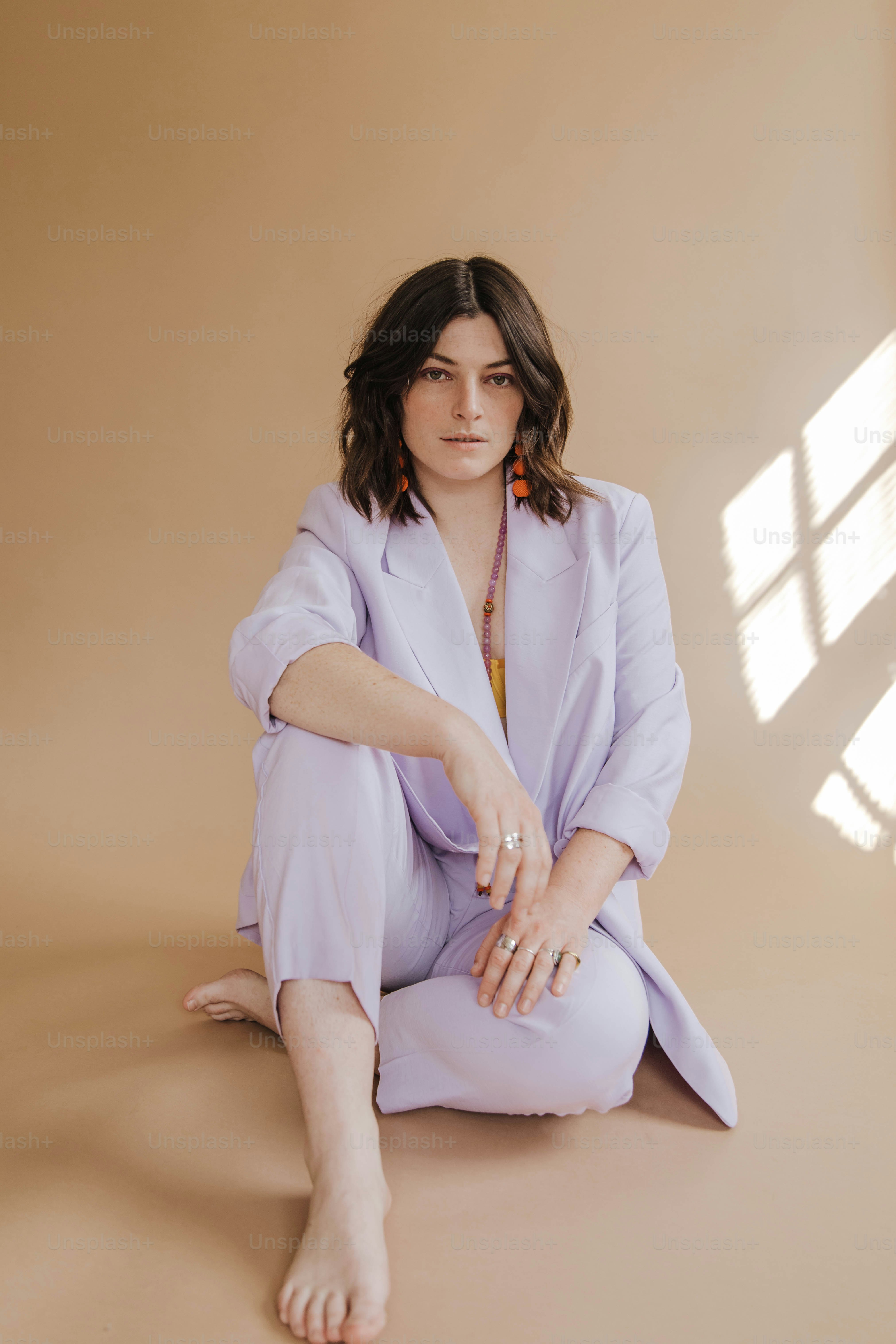 Una donna seduta sul pavimento in un abito viola