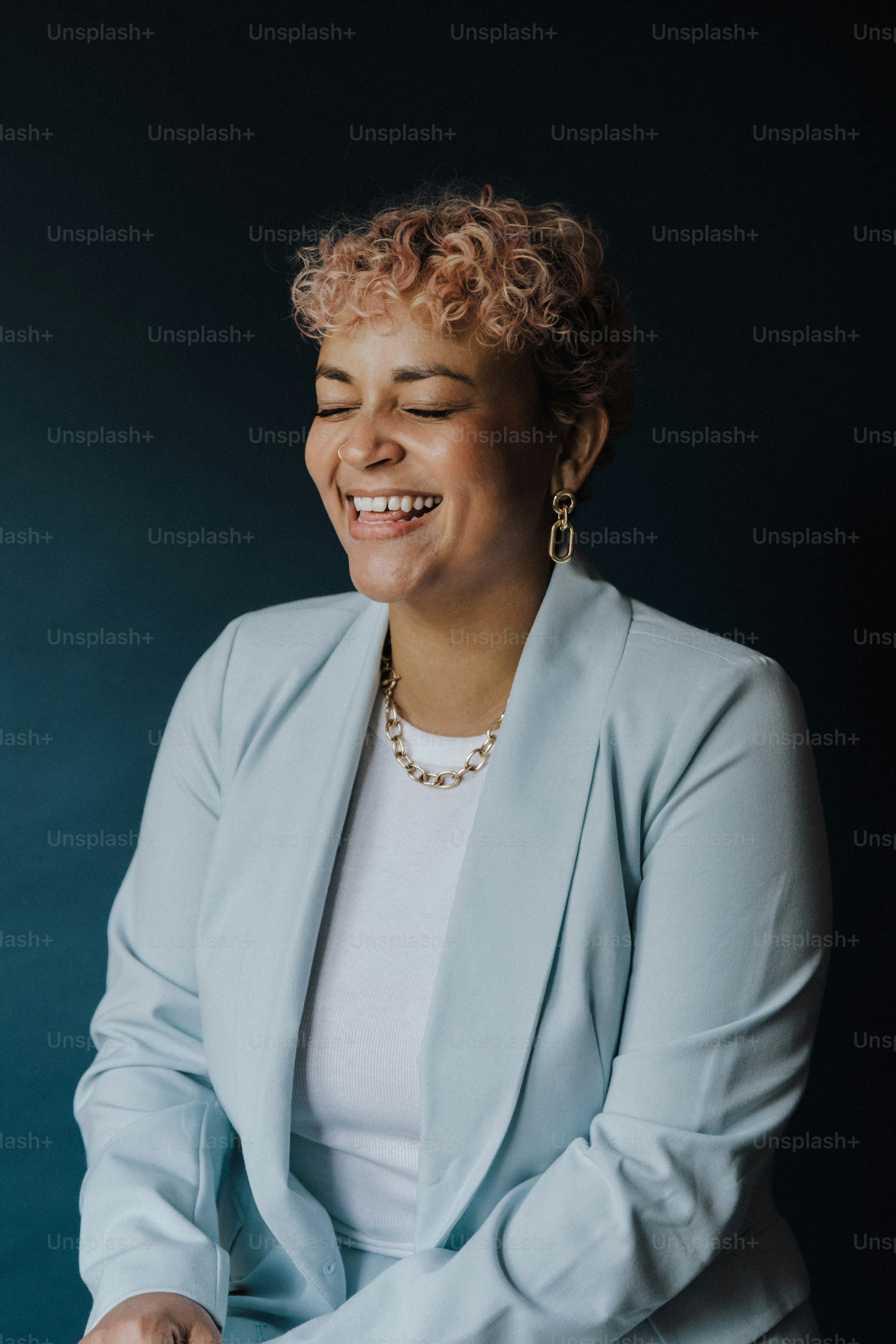 Une femme souriante vêtue d’une veste bleu clair