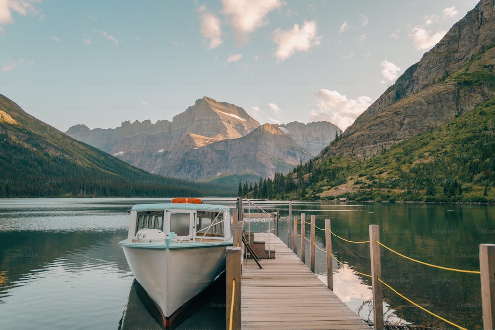 a boat docked at a dock in a mountain lake