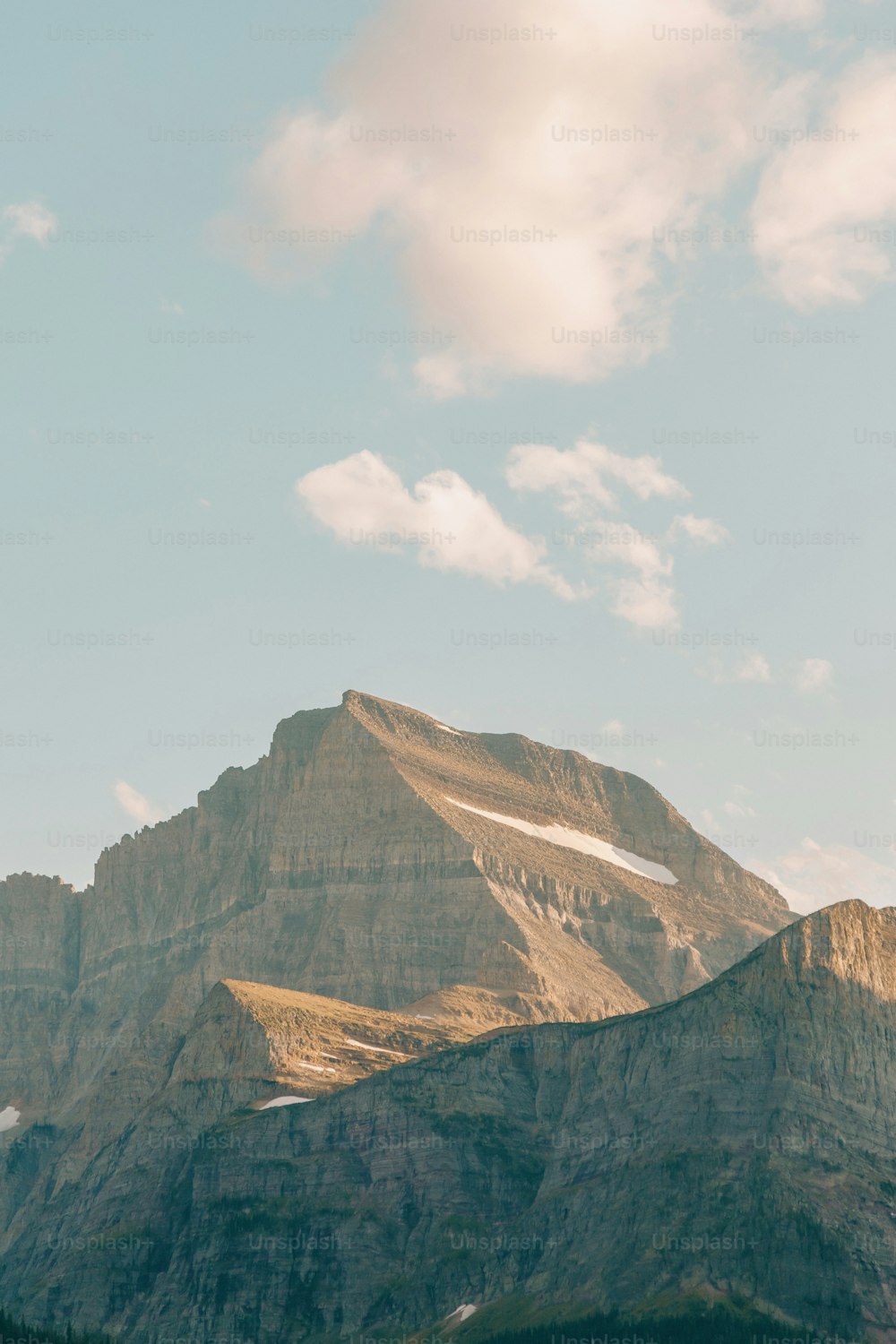 a view of a mountain with a few clouds in the sky