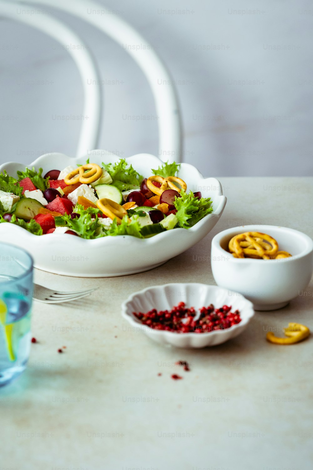 a table with bowls of food and a glass of water