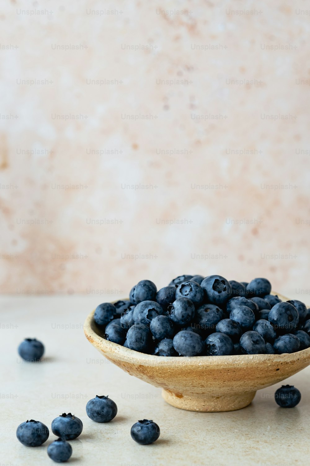 a wooden bowl filled with blueberries on top of a table