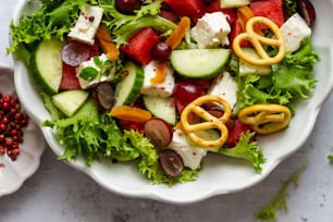 uma salada com pepinos, tomates, pepinos, cebolas, queijos