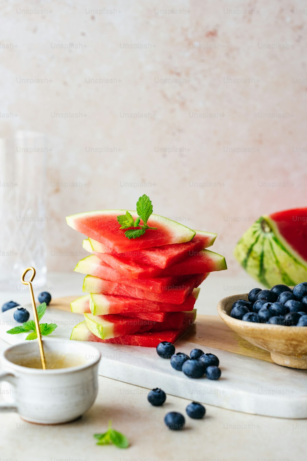 watermelon slices, blueberries, and mint are arranged on a table
