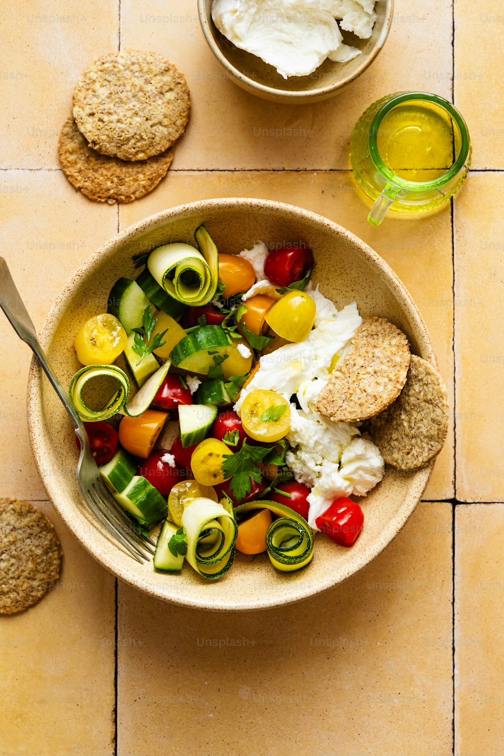 a bowl of vegetables and crackers on a table